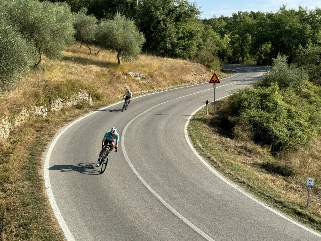 Cyclists riding on a curvy road through scenic hills